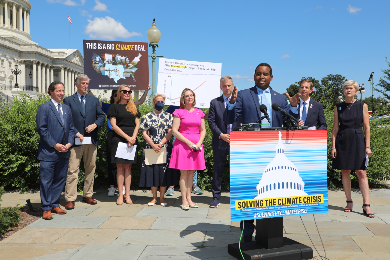 Representative Joe Neguse speaks at a Climate Crisis Press Event in front of fellow lawmakers