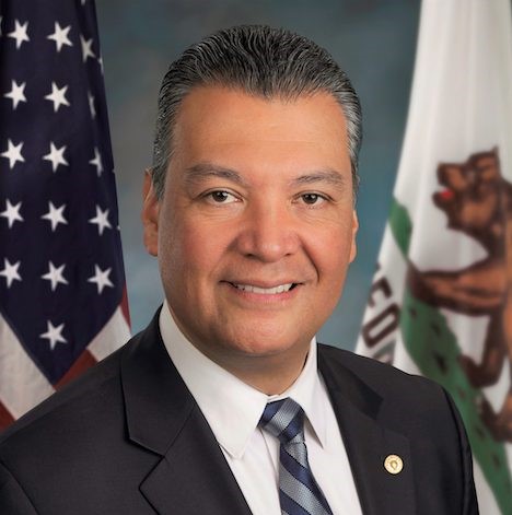 Sen. Alex Padilla posing in front of the American and California flags