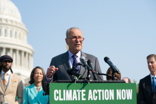 Senate Majority Leader Chuck Schumer speaks at a podium during a Climate Action Now press event in front of the Capitol building in DC