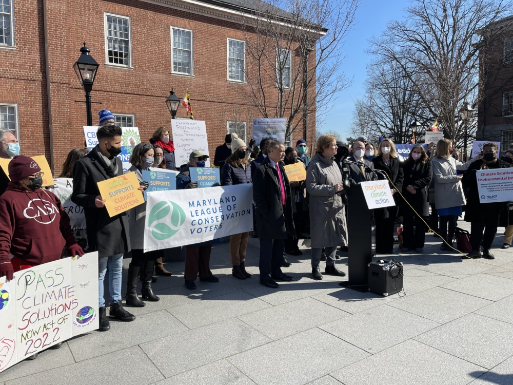 Maryland League of Conservation Voters personnel and partners gather behind a podium as Kim Coble (Maryland LCV Executive Director) speaks
