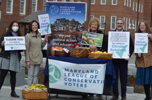 Personnel from the Maryland League of Conservation Voters pose outside of the Maryland State House with signage thanking electeds for voting for climate solutions