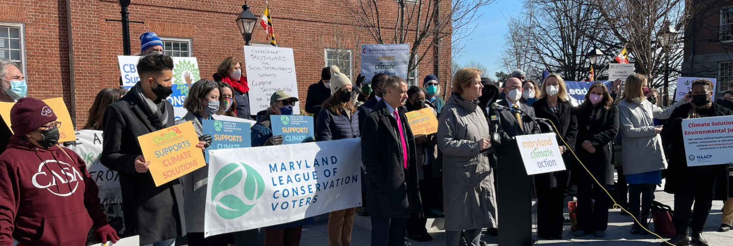 Maryland League of Conservation Voters personnel and partners gather behind a podium as Kim Coble (Maryland LCV Executive Director) speaks