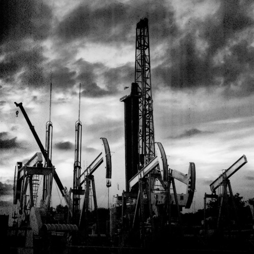 Black and white image of oil drilling rigs.
