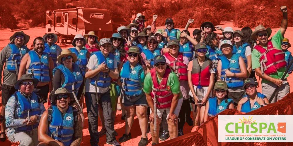 A large group posing for a photo in their life vests.