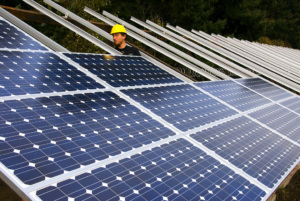 A construction worker inspects a solar panel.