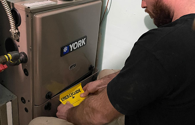 Repair person attending to a gas furnace.