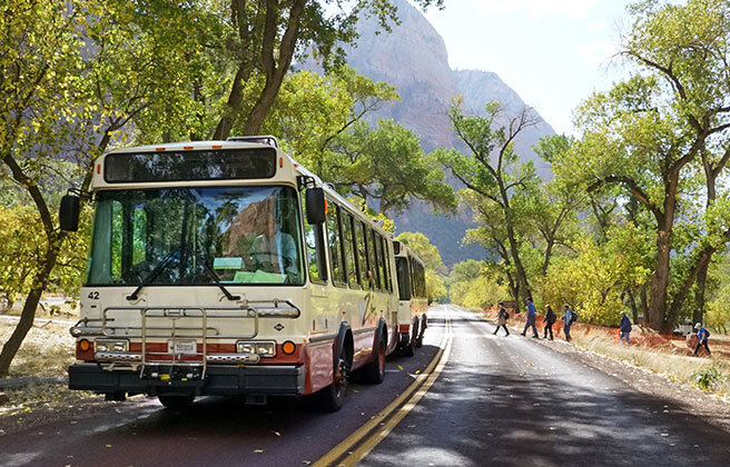 A shuttle bus drives through Zion National Park.
