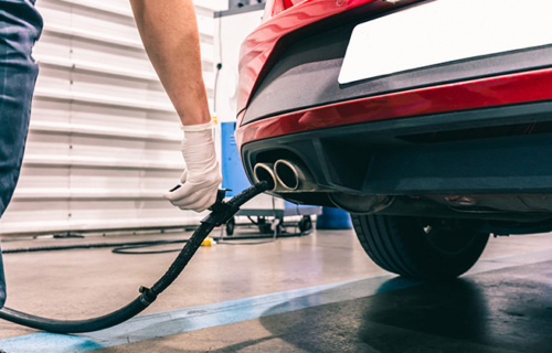 A worker completes a vehicle emissions test.