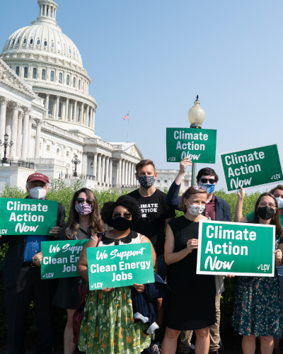LCV staff members hold “Climate Action Now” signs in front of the Capitol.