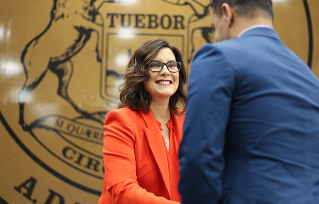 Governor Whitmer shaking hands with a person.