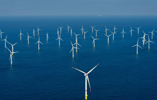 A group of wind turbines in the ocean.