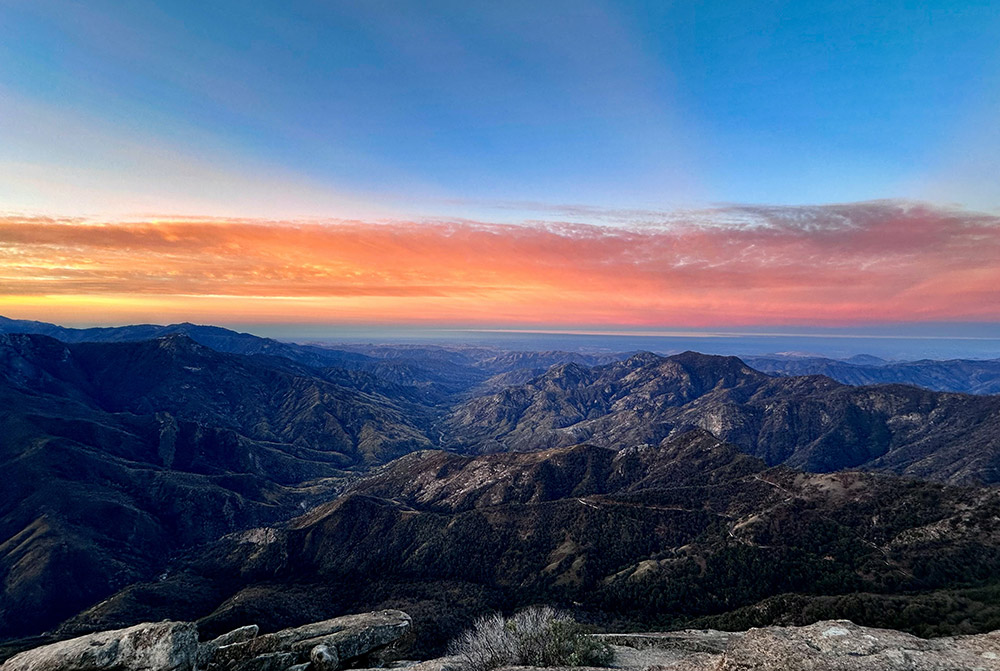 Landscape view of the sun setting over mountains in Sequoia National Park.