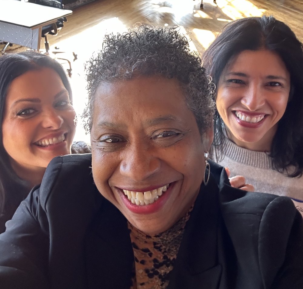 A group of 3 women smile in a selfie.