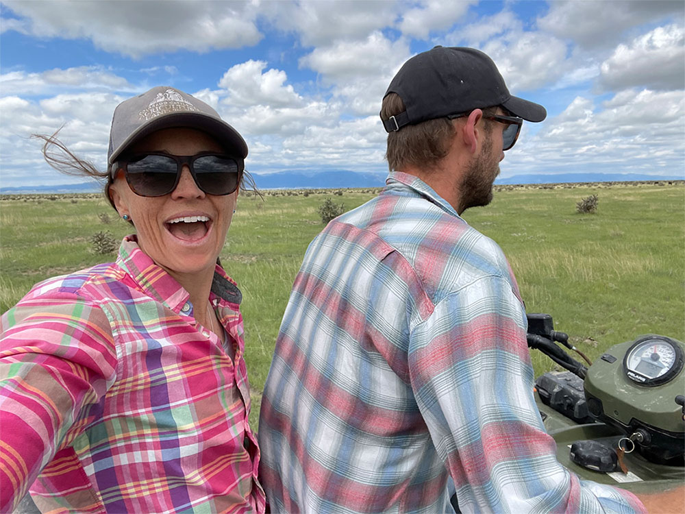 Maggie smiles on the back of a four-wheeler with her partner Nick.