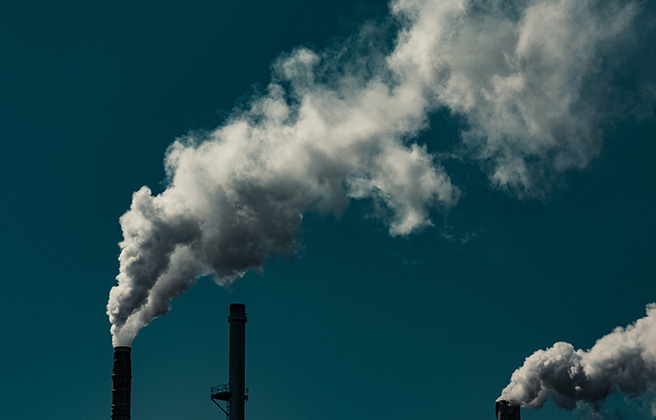 Smoke emanating from smoke stacks at a power plant.