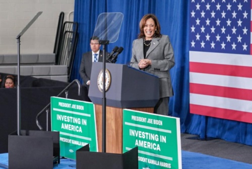 Vice President Kamala Harris stands on stage in front of a crowd at an Investing in America event
