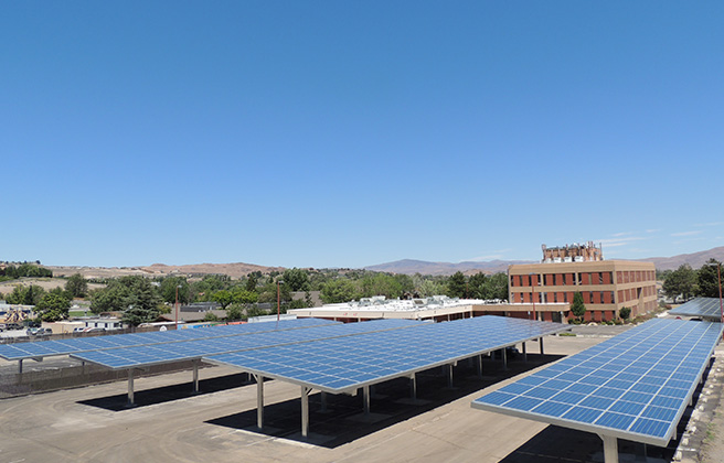 Solar panels on top of a school with mountains in the background.