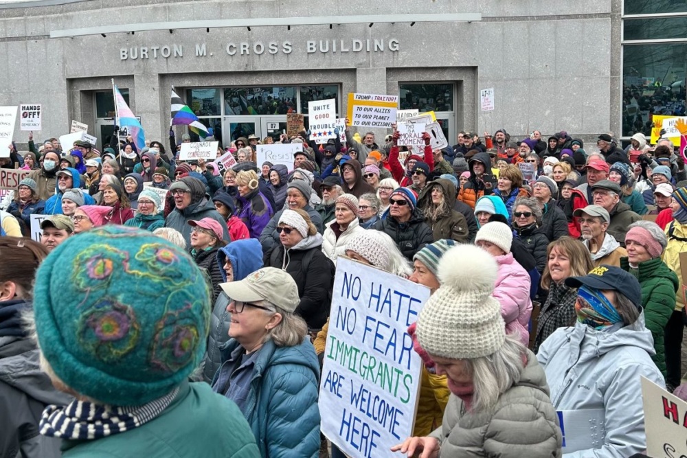 Protesters march past the Burton Cross Building in Maine.
