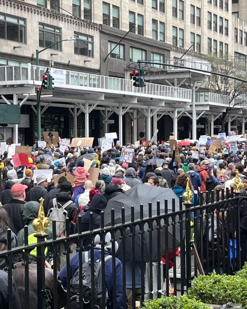 Protesters march down a New York City street in the rain.