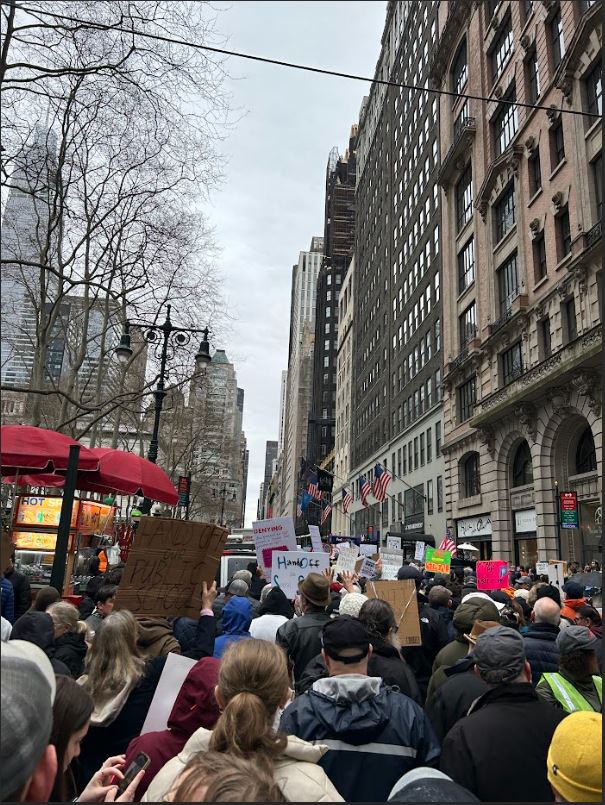 Protesters march down a New York City street in the rain.