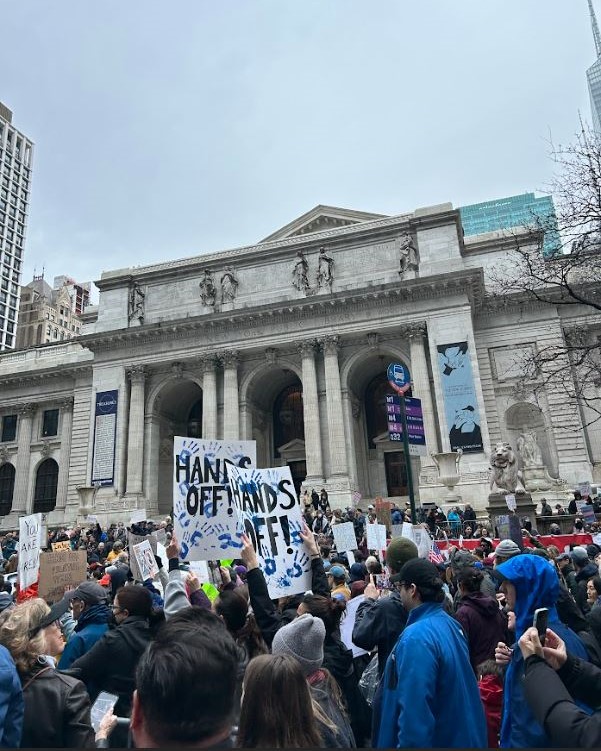 Protesters march past the main branch of the New York Public Library.