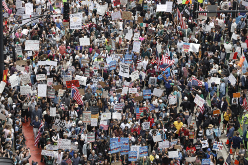 An aerial view of thousands of No Kings protesters carrying signs on a Chicago street.