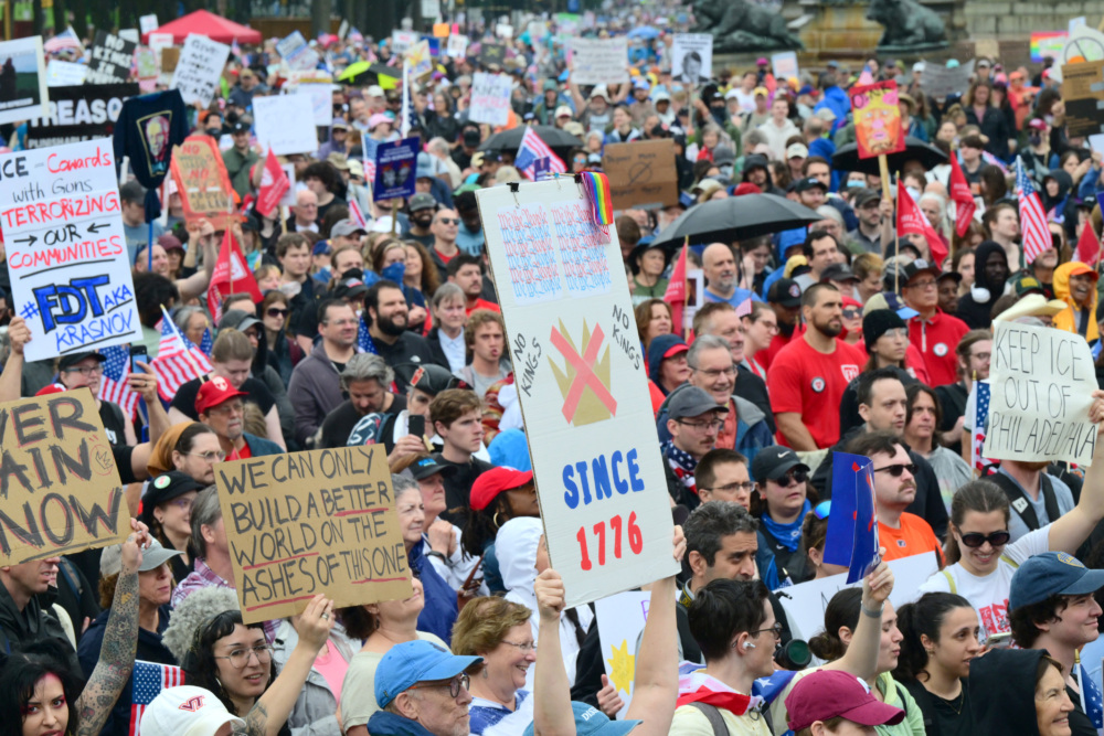 Protesters carrying signs crowd the streets of Philadelphia.