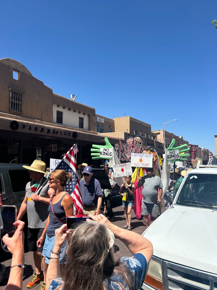 Protesters carry signs and flags in the streets of Santa Fe.
