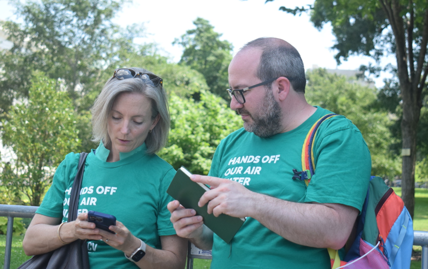 A woman and a man wearing matching green LCV shirts having a discussion.