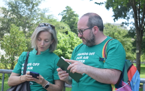 A woman and a man wearing matching green LCV shirts having a discussion.