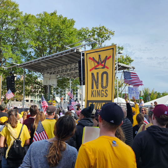 Protesters gather and wave American flags listening to the speakers at the No Kings rally in Washington, D.C.