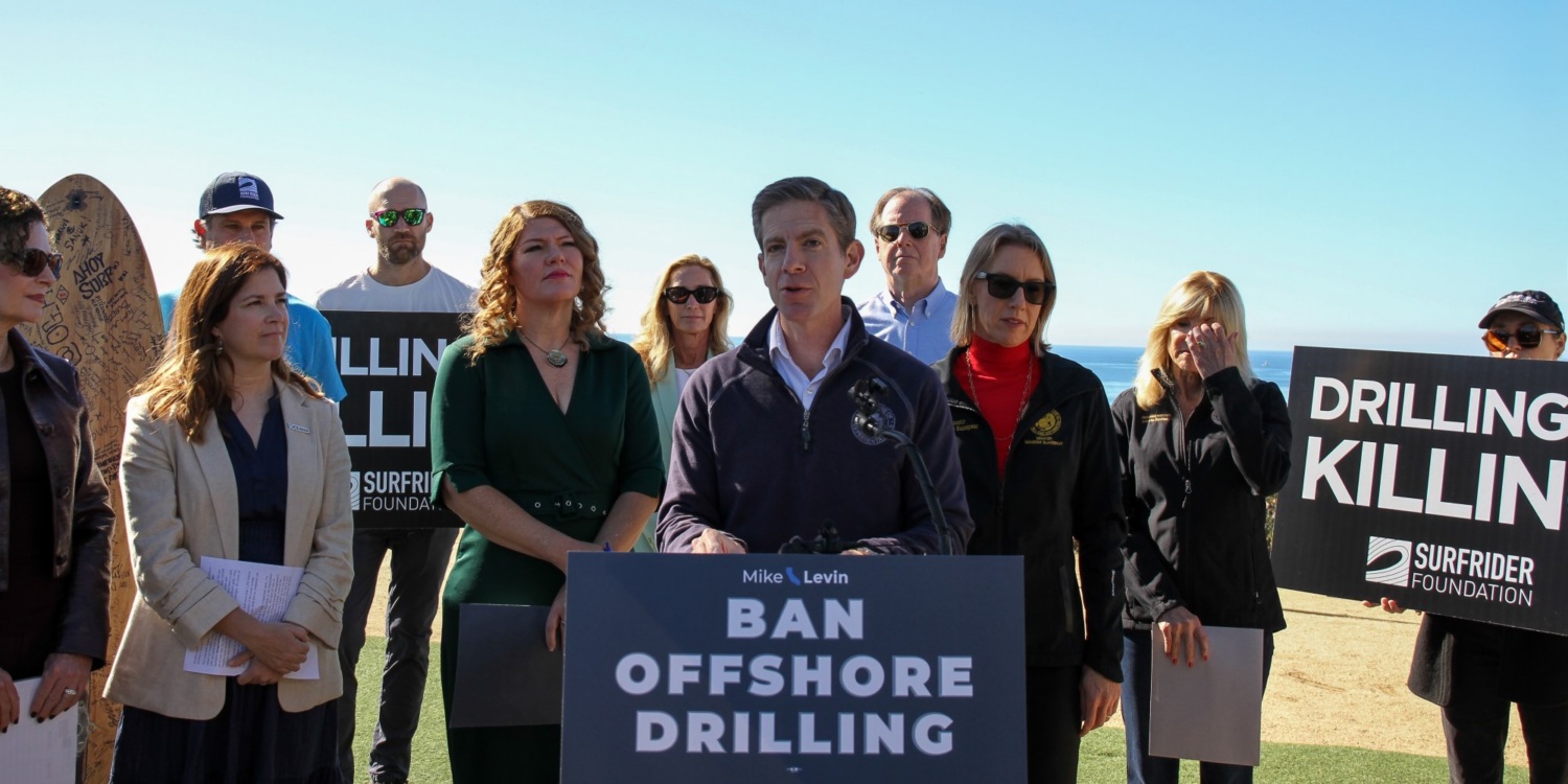 Rep. Levin speaks at a podium outdoors surrounded by supporters.