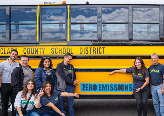 Activists from Chispa and partner organizations pose with a new clean energy bus