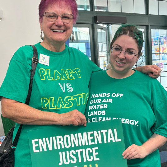 Climate Action volunteers pose with signs calling for environmental justice