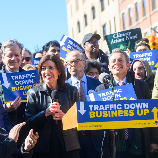 New York Governor Kathy Hochul smiles at the podium for a press conference on congestion pricing