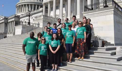 LCV staff wearing green shirts stand on the steps of the Capitol building.