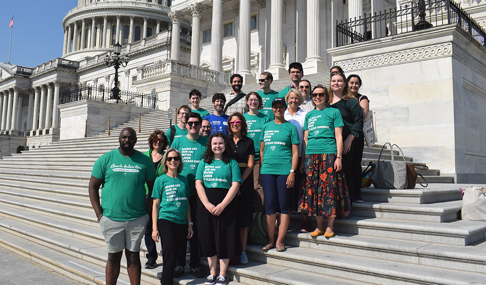 LCV staff wearing green shirts stand on the steps of the Capitol building.