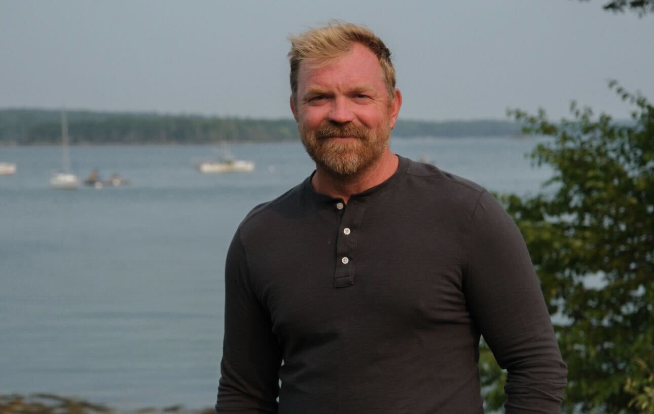 Graham Platner stands in front of a body of water.